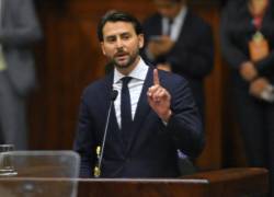 Esta fotografía tomada detrás de un cristal a prueba de balas muestra al nuevo presidente de la Asamblea Nacional de Ecuador, Niels Olsen, pronunciando un discurso después de ser juramentado.