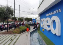 Una de las oficina de la Cooperativa CREA, con personas realizando largas filas en exteriores.