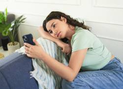 Una adolescente triste mientras usa el teléfono móvil y espera un mensaje o una respuesta de alguien.