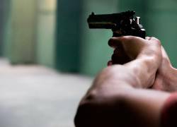 Fotografía referencial de un sujeto a punto de disparar un arma.