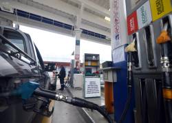 Despachador atiende a un vehículo que recargará de combustible en una gasolinera de Cuenca.