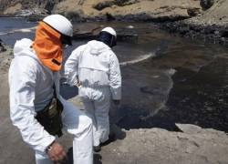 Cuadrillas de limpieza laboran para retirar petróleo de una playa en la provincia peruana del Callao.