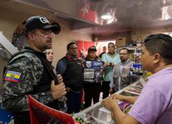 Fotografía que muestra al ministro del Interior , John Reimberg, hablando con un joven en un local.