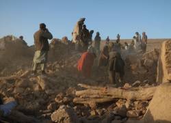 Residentes afganos limpian los escombros de una casa dañada tras el terremoto.