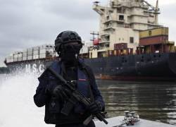 Un miembro del Comando de Guardacostas (COGUAR) de la Armada del Ecuador navega en una patrulla a lo largo de canales afluentes del río Guayas junto a terminales portuarias.