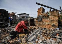 Los voluntarios limpian los escombros de una casa destruida como resultado del bombardeo en la aldea de Moshchun, región de Kyiv, el 9 de septiembre de 2022, en medio de la invasión militar rusa de Ucrania.