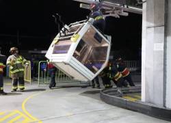 Personal del Cuerpo de Bomberos del Distrito Metropolitano de Quito manipulando una cabina que tuvo fallos en su funcionamiento.