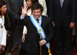 El nuevo presidente de Argentina, Javier Milei, saluda después de recibir la banda presidencial y el bastón de mando del presidente saliente Alberto Fernández.
