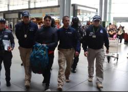 Foto de Germán Cáceres, principal implicado en el femicidio de María Belén Bernal, siendo escoltado por agentes de la Interpol en el aeropuerto de El Dorado, ubicado en Bogotá.