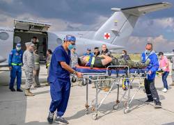 Fotografía cedida por las Fuerzas Militares de Colombia que muestra a integrantes de organismos de rescate trasladando un herido de un accidente aéreo este lunes.