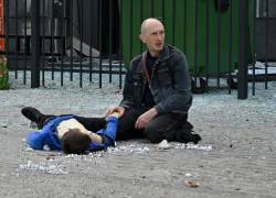Un apdre arrodillado junto al cuerpo de un adolescente que murió en un ataque con misiles rusos en una parada de autobús en Saltivka, el 20 de julio de 2022 en medio de la invasión rusa de Ucrania.