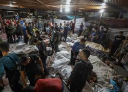 La gente se reúne alrededor de los cuerpos de los palestinos muertos después de que un ataque arrasara el hospital Ahli Arab en el centro de Gaza.