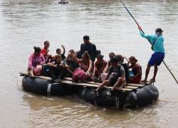 Una familia de migrantes de origen venezolano cruza un río, cerca a un puesto fronterizo en la ciudad de Tapachula, estado de Chiapas (México).