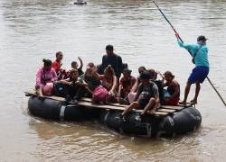 Una familia de migrantes de origen venezolano cruza un río, cerca a un puesto fronterizo en la ciudad de Tapachula, estado de Chiapas (México).