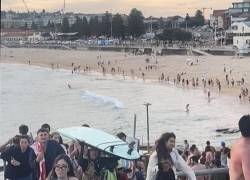 Bañistas huyendo de Bondi Beach después de que hombres armados abrieran fuego en Sídney.