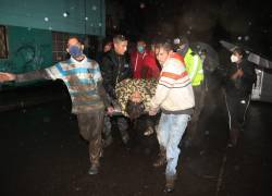 Un grupo de personas lleva a una víctima del aluvión en La Gasca, Quito.