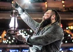 La otrora estrella del mundo de la lucha libre, Bray Wyatt, en su característica vestimenta mientras sostiene una lámpara como parte de su acto para una multitud de aficionados.