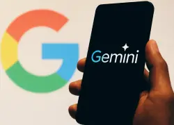 Hombre sujetando con la mano un teléfono celular con el logo de Gemini.