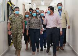 Fotografía que muestra al ministro de Salud, Jimmy Martin, hablándole a la gobernadora del Guayas, Zaida Rovira, en el pasillo de un hospital.
