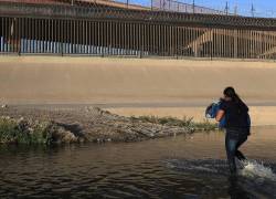 Fotografía del 5 de marzo de 2021 donde se observa a una mujer que intenta cruzar el Río Bravo hacia Estado Unidos, por la frontera de Ciudad Juárez, Chihuahua (México).