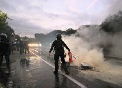 Un agente de la policía antidisturbios extingue un incendio en una barricada durante el paro nacional convocado por la CONAIE, la organización indígena más grande de Ecuador, en Quito el 15 de octubre de 2025.