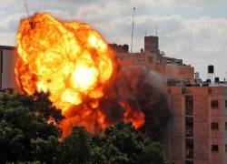 Una imagen tomada el 13 de mayo de 2021 muestra una bola de fuego que envuelve el edificio de Al-Walid que fue destruido en un ataque aéreo israelí en la ciudad de Gaza.