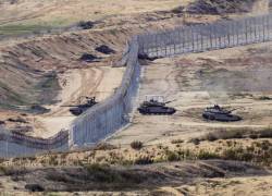 Esta fotografía tomada desde el sur de Israel, cerca de la frontera con la Franja de Gaza, muestra tanques del ejército israelí saliendo de la barrera de seguridad que rodea el territorio palestino el 22 de noviembre de 2023.