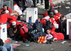 La gente se cubre durante un tiroteo en Union Station durante el desfile de la victoria del Super Bowl LVIII de los Kansas City Chiefs el 14 de febrero de 2024 en Kansas City, Missouri.