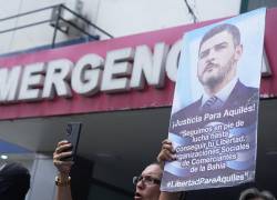Un simpatizante del alcalde de Guayaquil, Aquiles Alvarez, sostiene un cartel frente al hospital Alcívar.