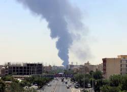 Humo de una refinería de petróleo se eleva sobre edificios residenciales en el sur de Teherán, Irán, el 15 de junio de 2025.