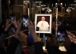 People take pictures of a memorial to Pepe Francis, inside The Metropolitan Cathedral of the Most Precious Blood, informally known as Westminster Cathedral, in central London on April 21, 2025, following the news of the death of Pope Francis. Pope Francis died on April 21, 2025 aged 88, a day after making a much hoped-for appearance at Saint Peter's Square on Easter Sunday, the Vatican said in a statement. (Photo by HENRY NICHOLLS / AFP)