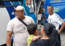 Varios de los afectados por el accidente, frente a los buses que chocaron.