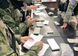 Fotografía que muestra a militares recogiendo billetes falsificados hallados en la Terminal de Quito.