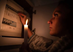 Fotografía referencial de una mujer revisando si ya volvió la luz durante la noche.
