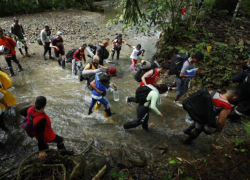 Migrantes cruzando por el Tapón del Darién.
