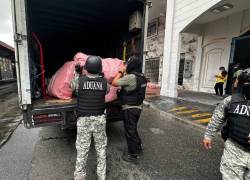 Fotografía que muestra a agentes del SENAE colocando la mercadería incautada en un camión de carga.