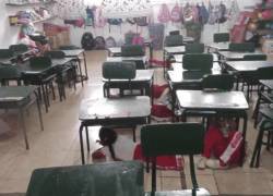 Imagen que muestra a estudiantes agachados bajo sus mesas durante el ataque armado.