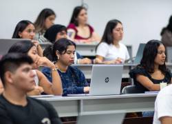 Un grupo diverso de estudiantes escucha atentamente durante una clase universitaria.
