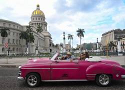 Turistas viajan en un antiguo automóvil estadounidense utilizado como taxi en La Habana.