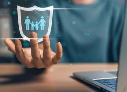Escudo de protección con padres e hijos en mano de una mujer.
