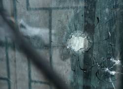 Se ve un agujero de bala en la ventana de la casa donde cuatro niños fueron asesinados por hombres armados.