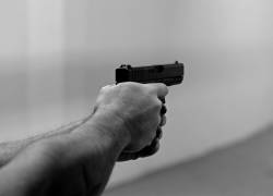 Fotografía de referencia de un hombre apuntando con un arma de fuego.