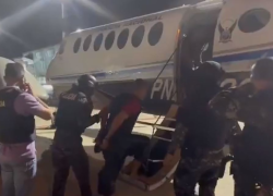 Captura de video en la que se observa al aprehendido abordar una aeronave junto a un contingente policial.