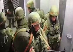 Militares rusos abordan el ascensor del edificio de departamentos Pokrovski, en Kiev.