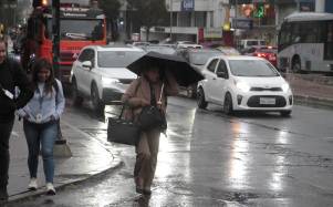Una persona cubriéndose de la lluvia.