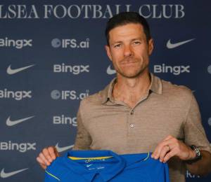 Xabi Alonso junto a la nueva camiseta del Chelsea.