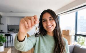 Fotografía referencial de una mujer con las llaves su vivienda recién adquiridad.