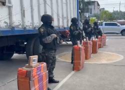 Imagen que muestra a policúas junto con los sacos de droga incautados.