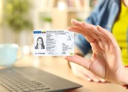 Persona sujetando una cédula de identidad ecuatoriana.