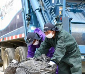 Dos trabajadores del Consorcio Durán Limpio recogiendo desechos en la calle.